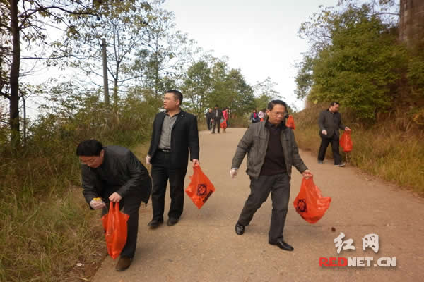 参与活动的干部职工手拿垃圾袋清理垃圾