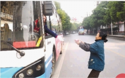 12月11日中午，长沙市湘春路，公交车一停，莫娭毑就端着做好的饭菜送过去。