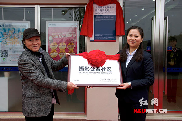 12月13日上午，湖南省摄影家协会副主席张黎明（左）为新成立的全国首个“摄影公益社区”向长沙开福区金泰路社区负责人授牌。