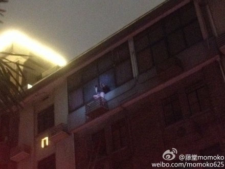 图说：有居民爬出窗外站在空调外机上求生。微博图（请私信新民晚报新民网以奉稿酬）