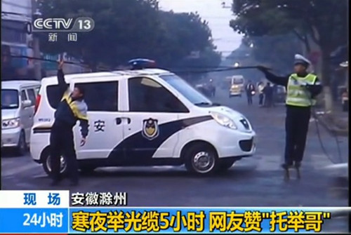 [视频]交警寒夜举光缆5小时 被网友赞托举哥