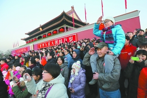 昨天清晨，在天安门城楼东侧观礼台，一对前来观看升国旗仪式的父子向国旗敬礼。当天，天安门城楼观礼台第三次在元旦面向观看升国旗仪式的各地游客开放。