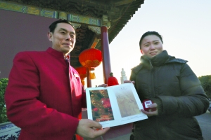 昨天上午，在天安门城楼上，一位参观城楼的游客接过工作人员送上的证书。据介绍，这位来自黑龙江的游客有幸成为2014年参观天安门城楼的首位游客。