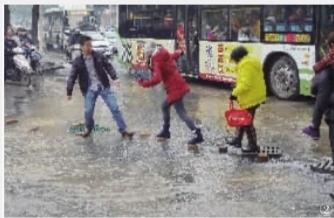  ②几名行人小心地从积水路面中铺的砖块上走过。