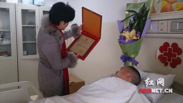 湖南省红十字会、中华骨髓库湖南分库主任何一平授予李智捐献造血干细胞荣誉证书。