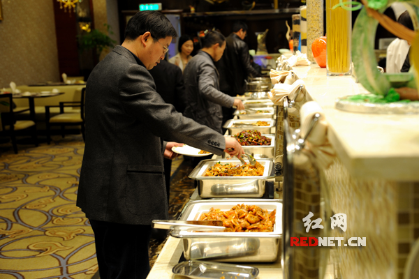 在长沙某酒店内，参加长沙市十四届人大二次会议的代表们正在吃自助餐。