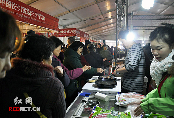 某展台前,市民在品尝食品。