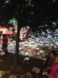 车祸现场，两村民正在捡拾散落的饮料。网友小向供图