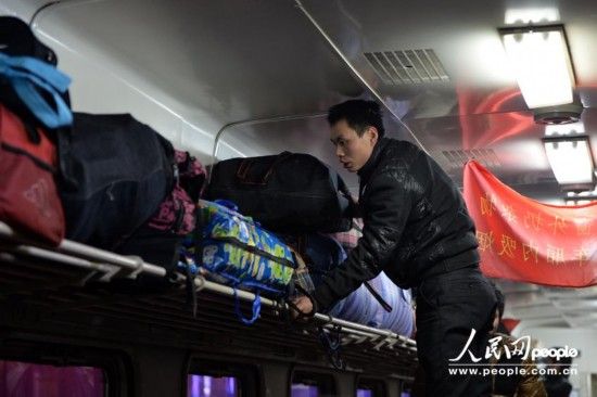 乘客在车厢摆放行李。(人民网记者 翁奇羽 摄)