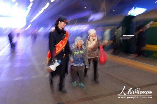 爱心引导员带领乘客寻找车厢。(人民网记者 翁奇羽 摄)