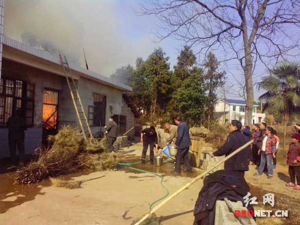 浏阳市洞阳镇长东村七星塘组一村民家突发大火，当地村民排着长队从水塘取水灭火。