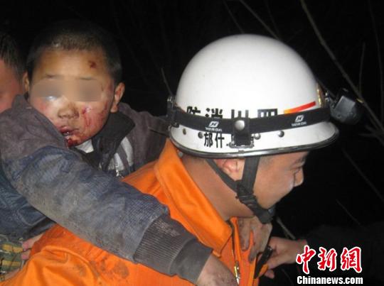 受伤的涛涛被消防官兵从废弃的石灰窑洞中救出。　何伟　摄