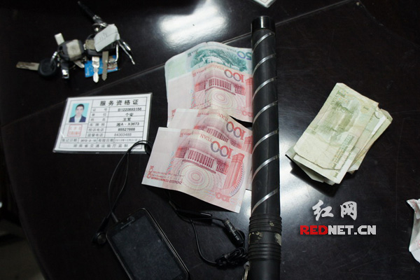 湘AT2398套牌的士上査获假人民币350元，警用电警棍一根