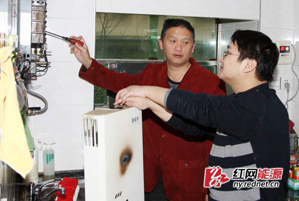 郑李志（左）在巴陵石化岳化金盆社区一居民家中维修燃气热水器。