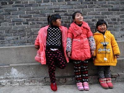 1月25日，6岁的陈鑫(中)在村庄路口与同伴玩耍。她的父母在浙江杭州打工，今年春节，只有母亲能够回来和她团聚。