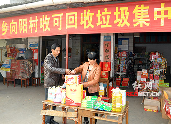 安乡县安康乡向阳村的农民上交可回收垃圾后，到商店兑换商品。