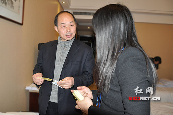 登记身份后，蒋昌永代表到怀化代表团领取代表证、房卡和参会资料。