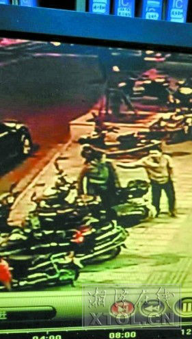 一男一女在偷盗电动车（监控视频截图）)