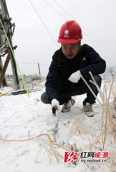 2月11日，湖南省娄底市新化电力公司员工在温塘镇神仙岭村安装直流融冰装置进行融冰。