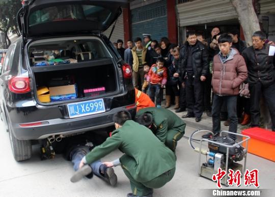 遂宁越野车将正在路边行走的老年夫妇撞倒压在车底，救援官兵正在营救。 刘琳 摄