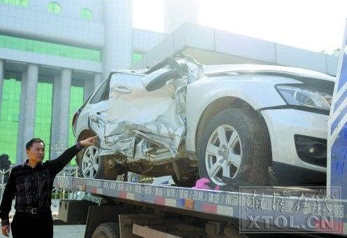 ２０１３年１１月２１日，受害人魏新招将被砸坏的奥迪越野车摆放在市中级法院门口。（记者 张哲 摄）