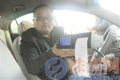 一个出租车司机正在展示机打发票 记者 张媛 摄