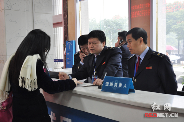 孙险峰（右一）在大厅值班，耐心解答纳税人的咨询。