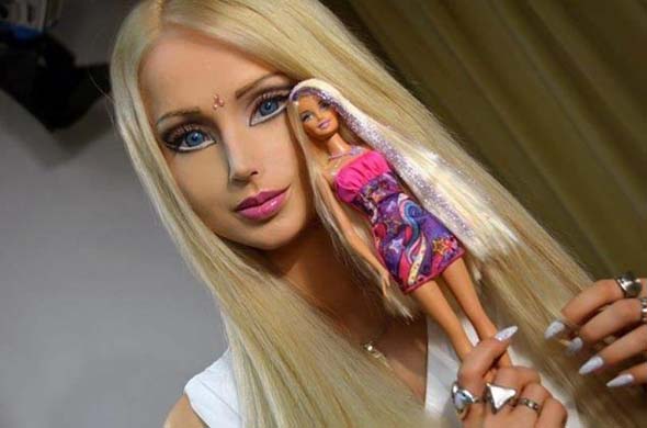 乌克兰模特瓦莱里娅拿着一个和自己形象极其相似的芭比娃娃（网页截图）