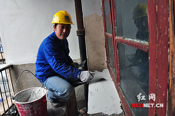 长沙开福万达项目部做内部装修的王师傅在唐娭毑的阳台开展抹灰作业。