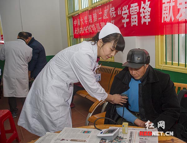 护士杨晶[右二]为一位老人作常规的血压测量。
