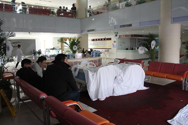 安放着死者遗体的病床被摆放在医院一楼大厅中