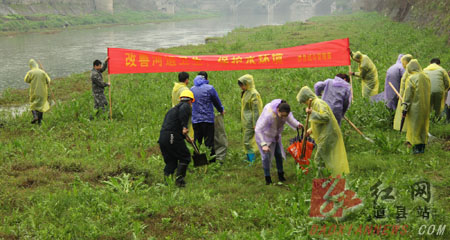 道县城管局工作人员与志愿者在清理河道内的垃圾。