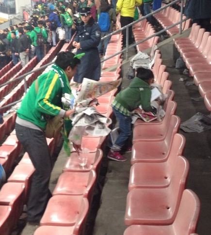 国安赛后看台上一片狼藉 女童捡垃圾感人(图)