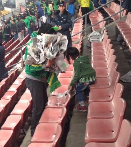 国安赛后看台上一片狼藉 女童捡垃圾感人(图)