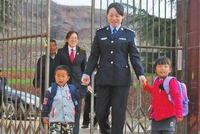 姐弟俩拉着女干警的手高高兴兴上学校
