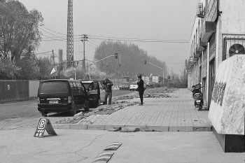 在济南市殡仪馆停车场门外,一辆非殡仪馆遗体运输车直接停在了一家墓地销售点门前。 本报记者 张榕博 摄