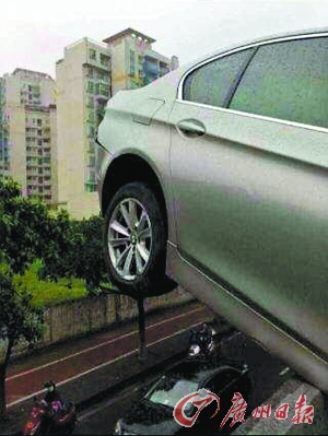 豪车悬空停在高架桥上。高架桥下行人车辆来往，若车跌落后果不堪设想。（图片来自网络）