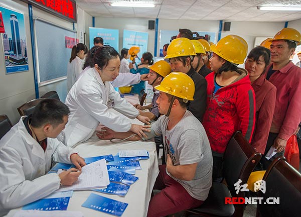 3月31日，长沙开福区伍家岭街道社区卫生服务站的医务人员正在为华创国际广场建筑工地的农民工进行免费体检。