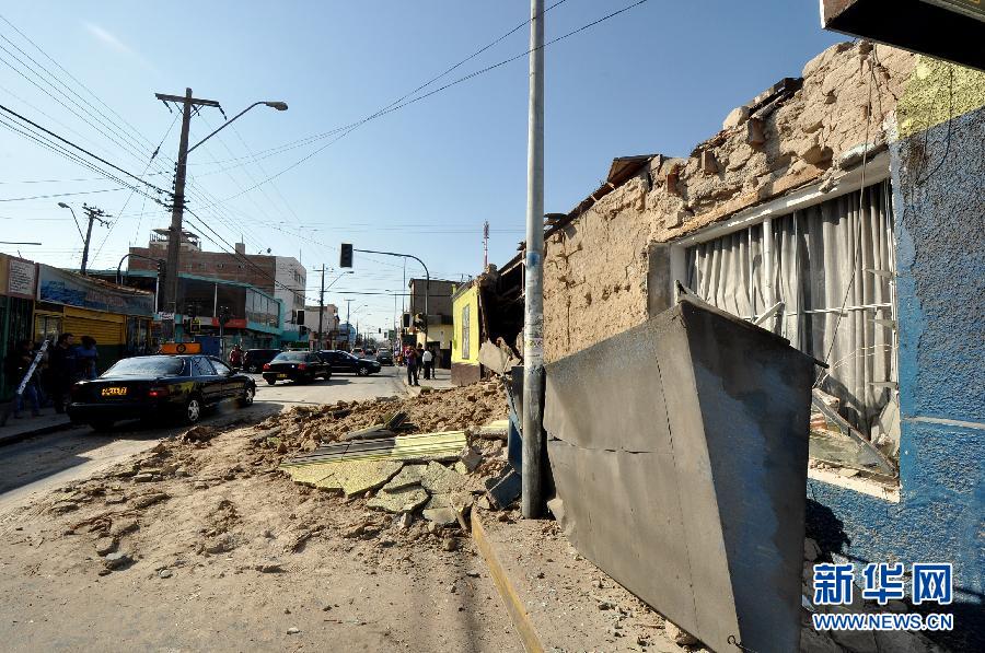 4月2日，在智利北部的阿里卡，车辆驶过被毁房屋。
