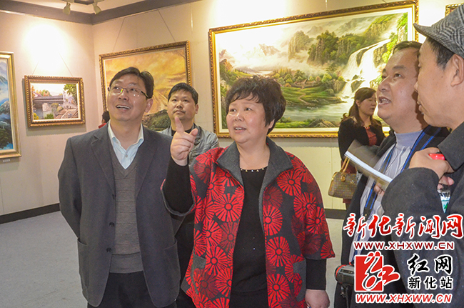 新化县委常委、宣传部长李劲柳正在欣赏彭勃作品