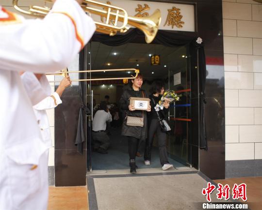 图为当天骨灰在哀乐和鲜花的伴随下送往海葬举行点　严初　摄src=