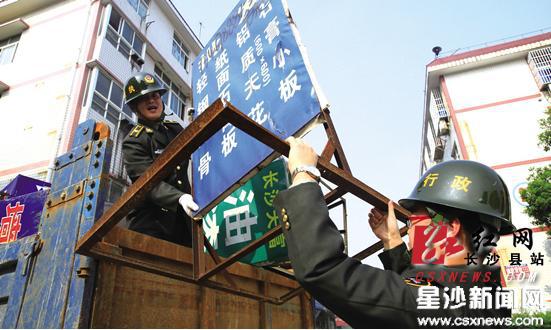 昨日，城管执法人员针对众鑫建材市场店外经营、乱堆杂物等现象进行集中整治，查扣违规落地灯箱、户外广告牌百余个。刘晓东摄