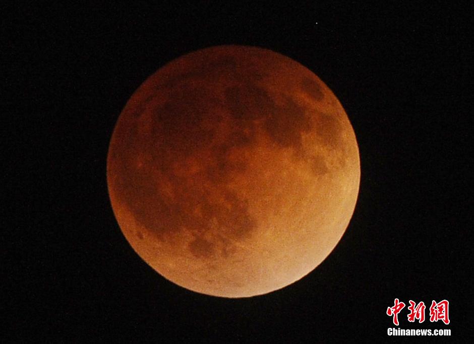 这是4月15日在墨西哥首都墨西哥城拍摄的月全食过程中的月亮。当日,今年首次月全食在天空上演,北美洲和南美洲的大部分地区都可以看见此次月全食的全过程。发生月全食时,由于波长较长的红光不容易被地球大气层散射,因此月全食期间的月亮也就变成了红色,也就是平常所说的“红月亮” 新华社发