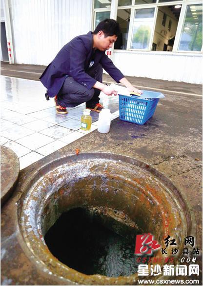在湖南汽车城永通有限公司(一汽大众4S店)，执法人员将下水井打开准备取水样时发现水的表面漂浮着一层厚厚的白色油漆。