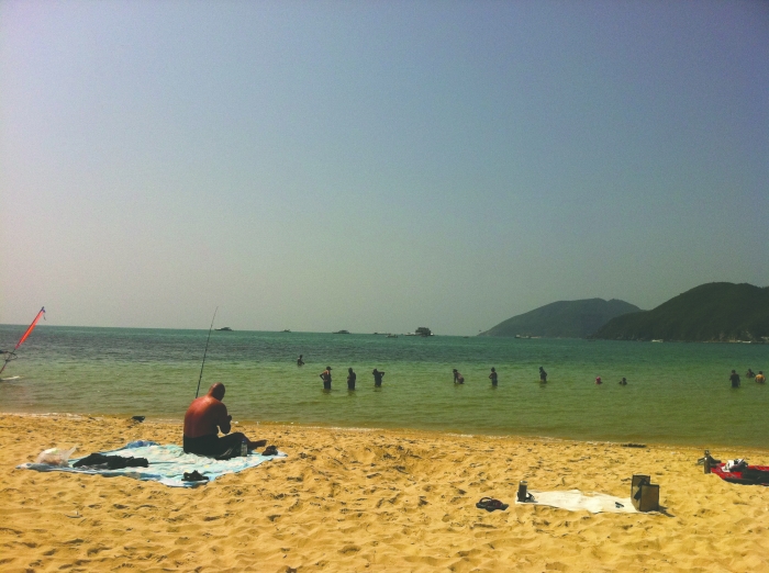 17日,一名银屑病患者在大东海沙滩晒太阳