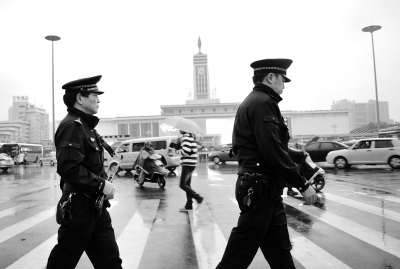▲5月4日，长沙火车站附近，芙蓉巡警大队民警持枪在路面巡逻。记者 李健 摄　