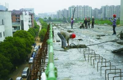 5月5日，长沙洞井路高架桥，工人在工地施工。该高架桥穿越长沙民政职业技术学院，桥段已基本完工。记者 武席同 摄