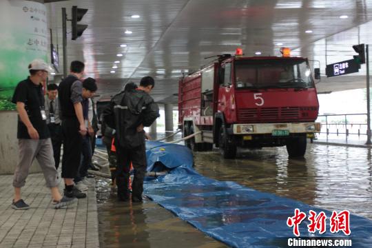 为防止水涌进候机楼，工作人员正忙着铺管抽水冒韪摄
