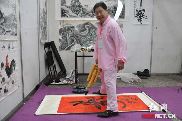 长沙年近六旬的刘长春现场展示“铁笔关公刀书法”。
