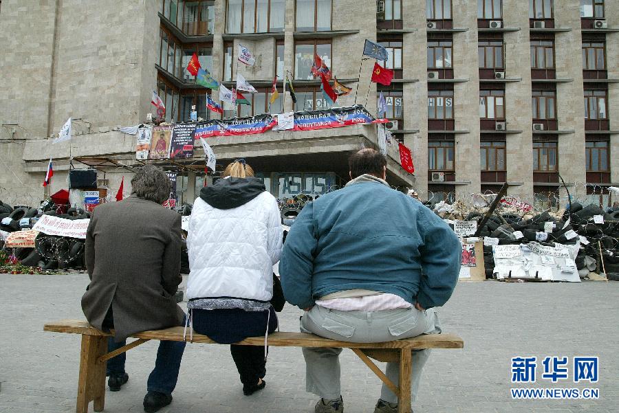 5月8日，在乌克兰东部城市顿涅茨克，人们坐在州政府大楼前。乌克兰东部亲俄派8日宣布，他们仍将按计划于11日就今后自身地位举行公民投票，乌克兰全国和解前景仍不乐观。新华社发（亚历山大·叶尔莫琴科摄）